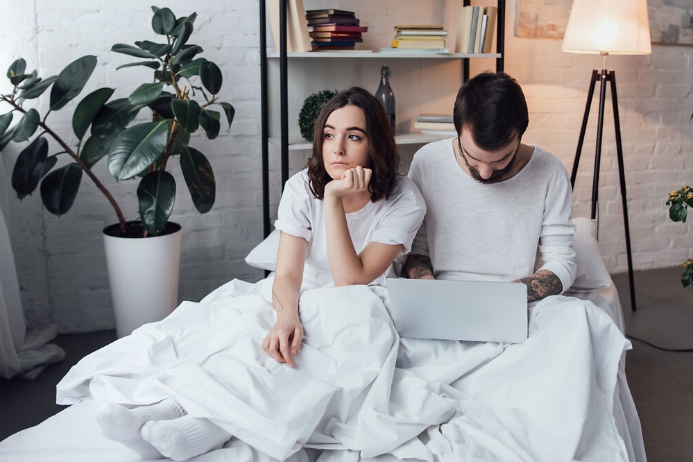 Unhappy couple with who need a bed frame for active couples