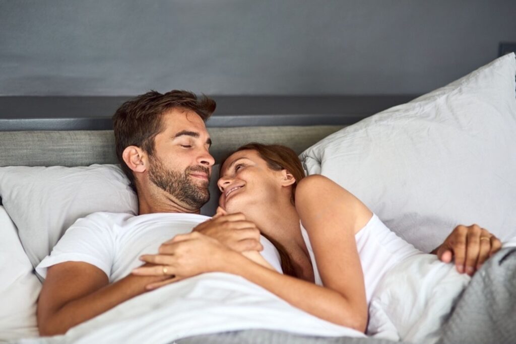 Couple discussing sleep preferences on a no squeak bed frame